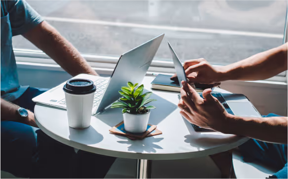 Two people working together on a laptop and tablet