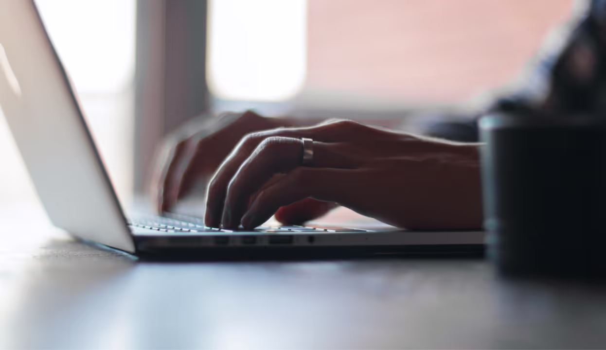 Hands typing on a laptop