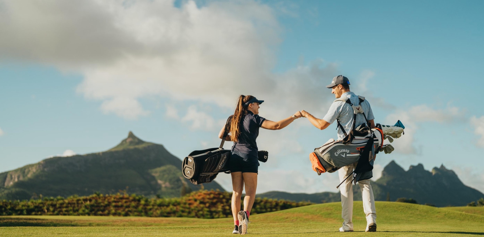 Golfers on the Moka Rangers Sports Club driving range with the Moka mountains behind